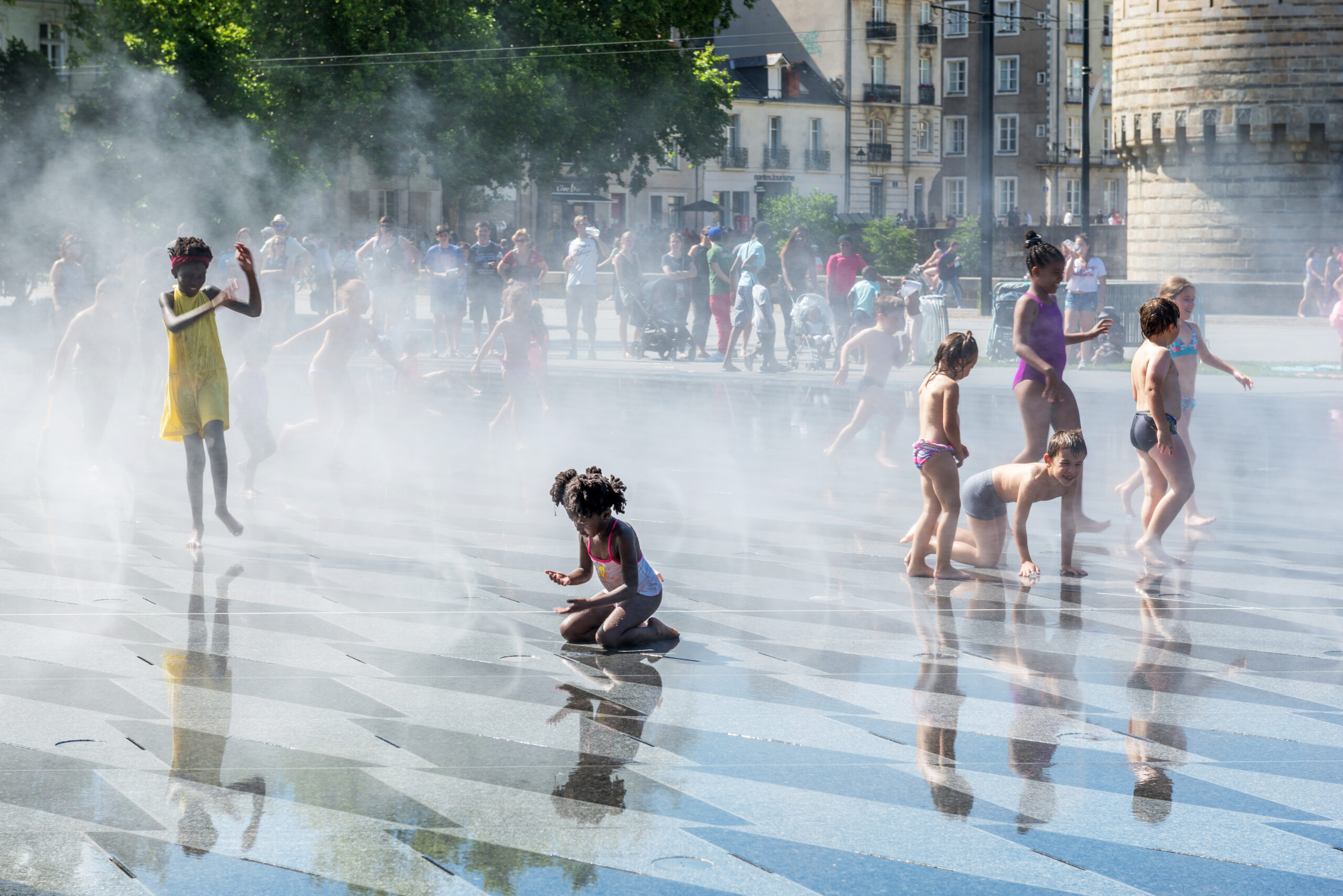 Children play in the fountain in front of the fortress in Nantes, France.